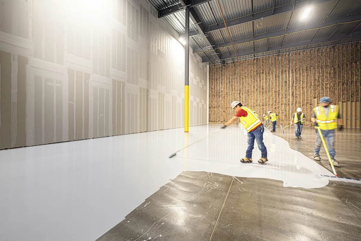 Floor coating being rolled onto a prepared concrete slab